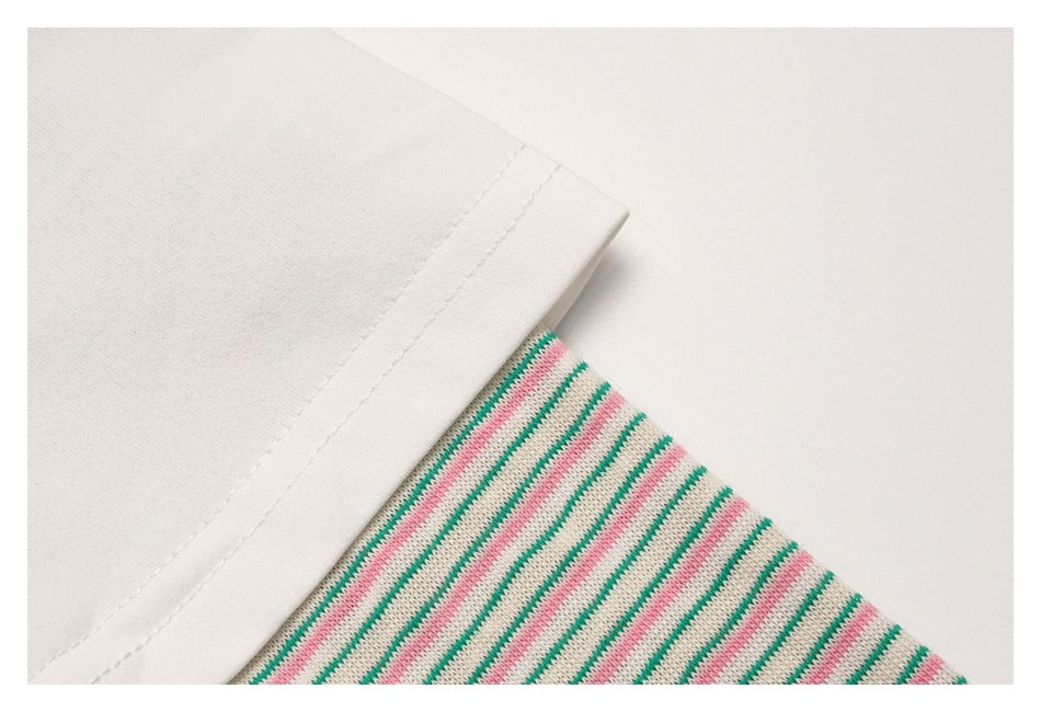 Close-up of the white short sleeve layered over a pink-and-green striped sleeve.