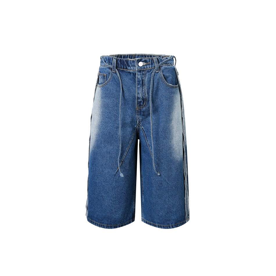Faded blue wide-leg knee-length denim shorts with front drawstring ties, button fly and raw-edge side seams