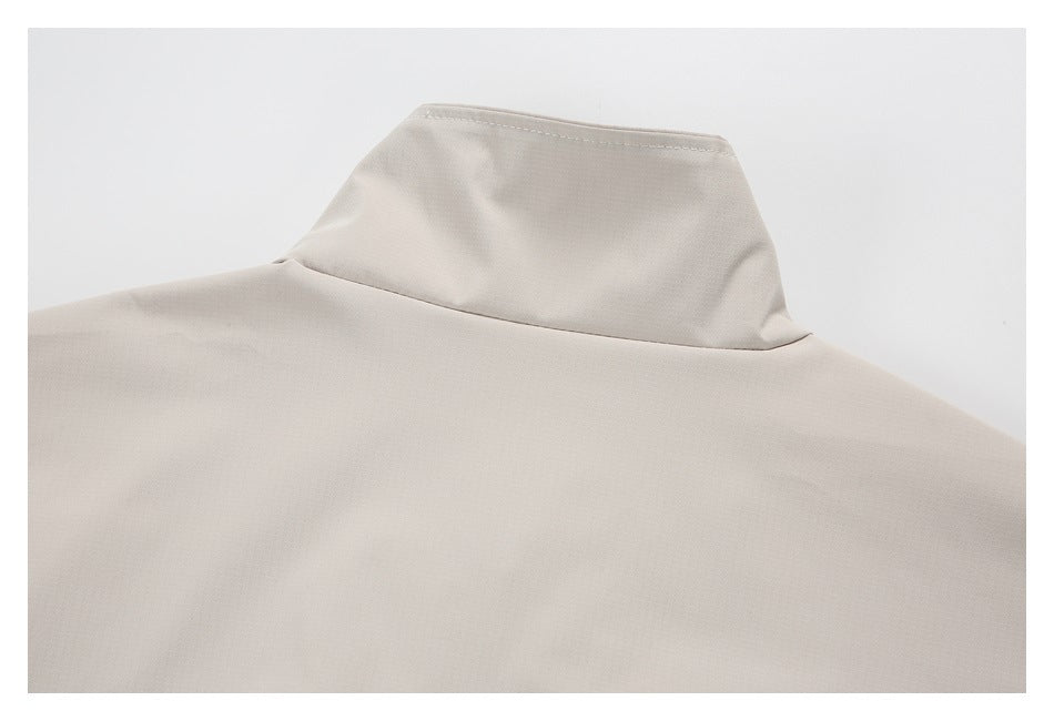 Close-up of a light beige garment's raised collar and shoulder seam.
