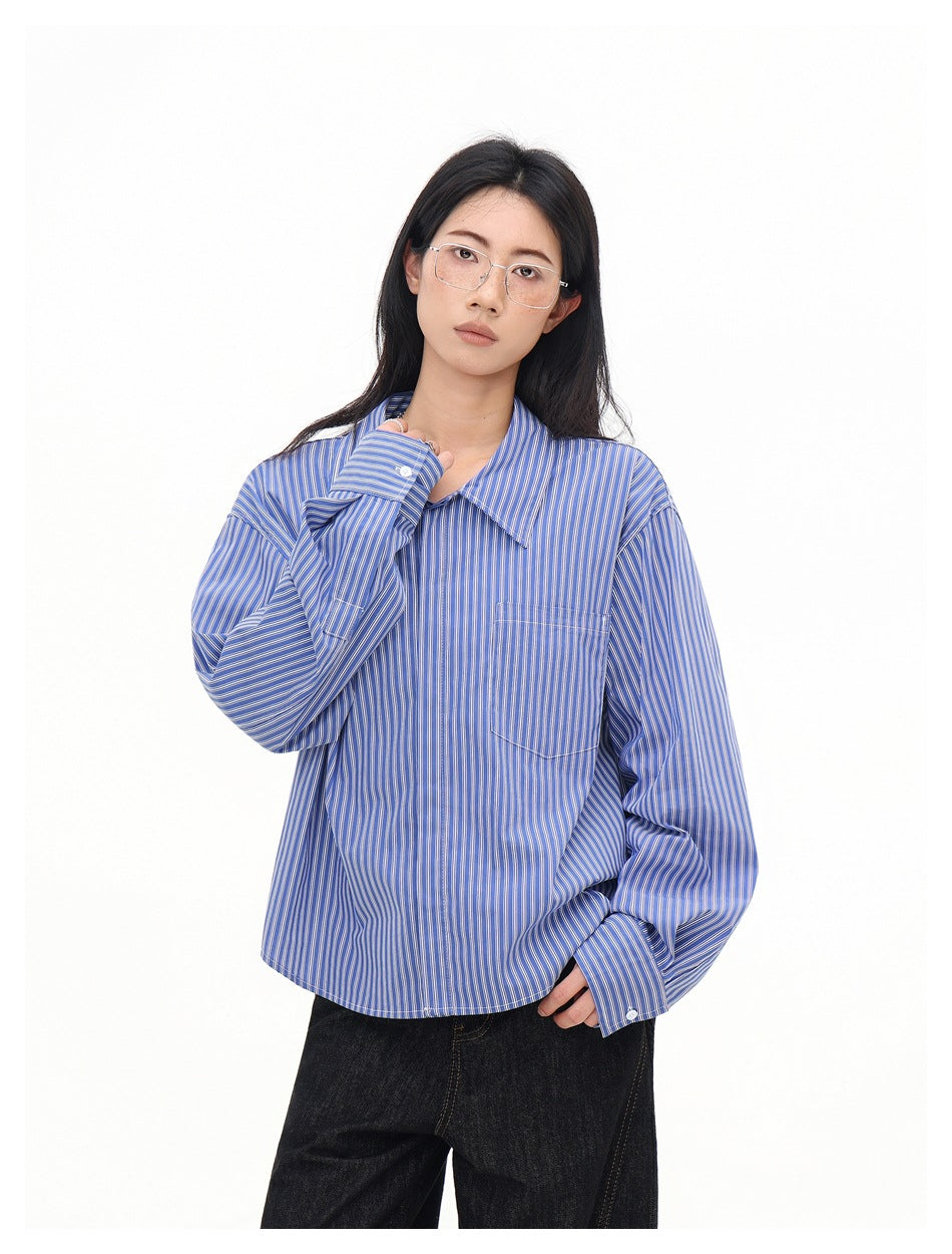 Model wearing a blue-and-white striped collared shirt with long sleeves and a chest pocket.