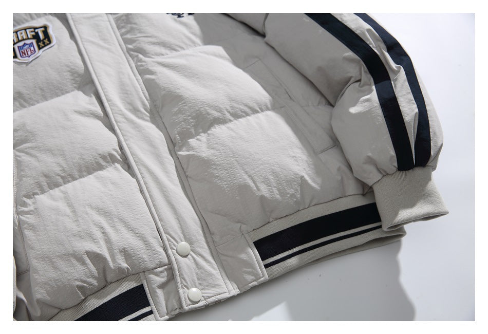 Close-up of the off-white jacket front with snap buttons, a striped ribbed hem, and a black-striped sleeve.