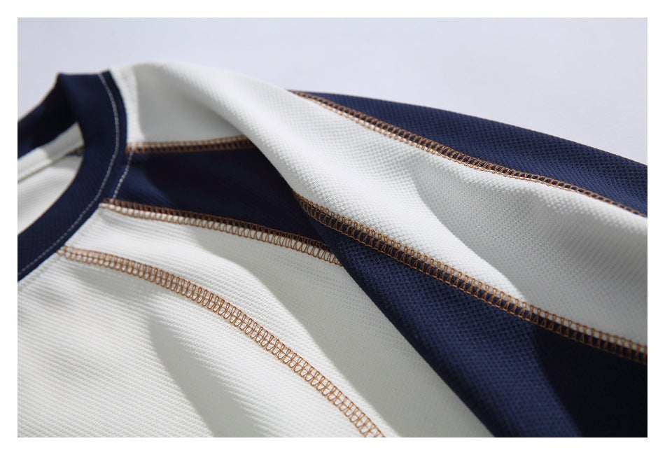 Close-up of the shirt's ivory and navy shoulder panels and contrasting overlock stitching.