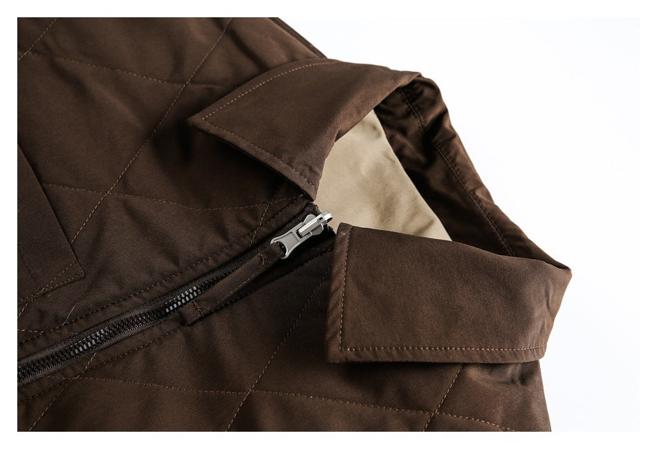 Close-up of a dark brown quilted jacket collar, zipper, stitching, and beige lining.