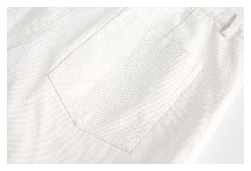Close-up of a large patch pocket stitched onto ivory fabric.