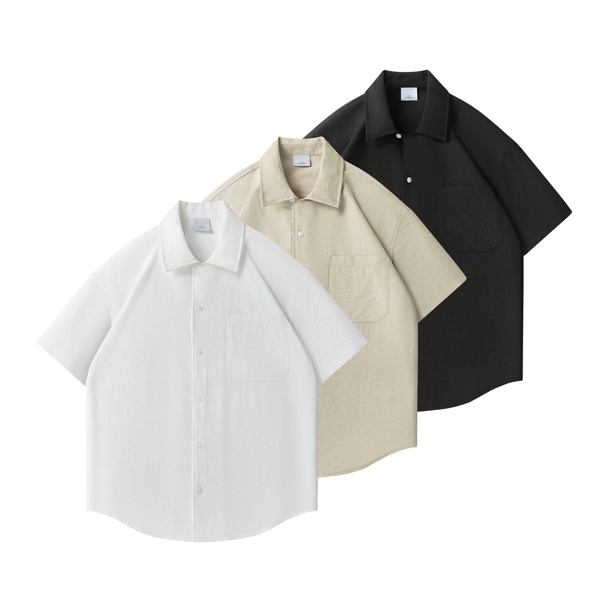 Three flat-lay short-sleeve button-up shirts with chest pockets in white, beige, and black.