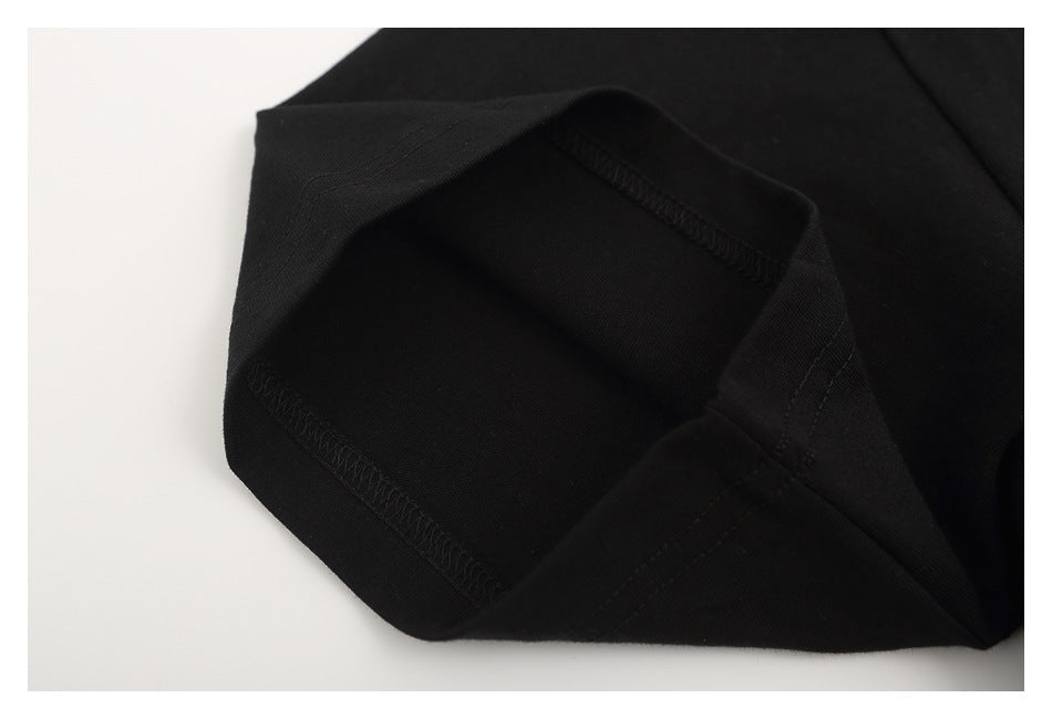 Close-up of folded black T-shirt fabric showing an overlocked seam.