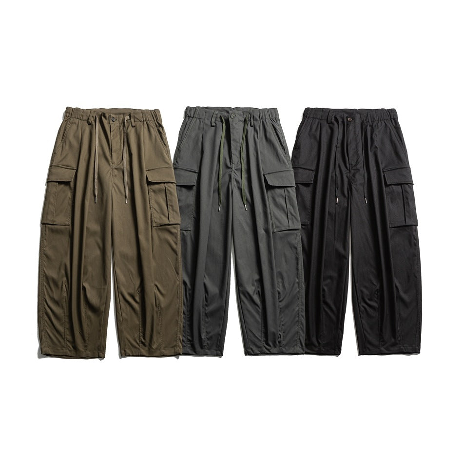 Front view of wide-leg cargo pants in olive, gray, and black, each with a drawstring waist and flap pockets.