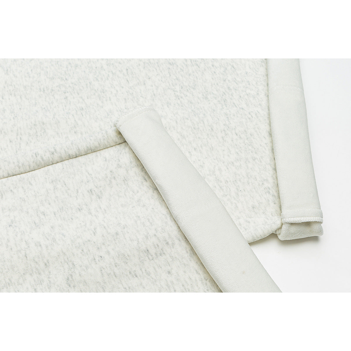 Close-up of ivory trousers showing a pocket opening, stitching, and folded hem edge.