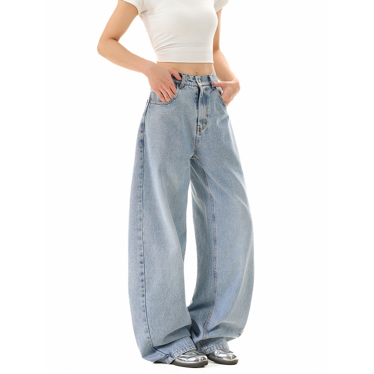 Model wearing light-wash, very wide-leg jeans with a white cropped T-shirt, front three-quarter view.
