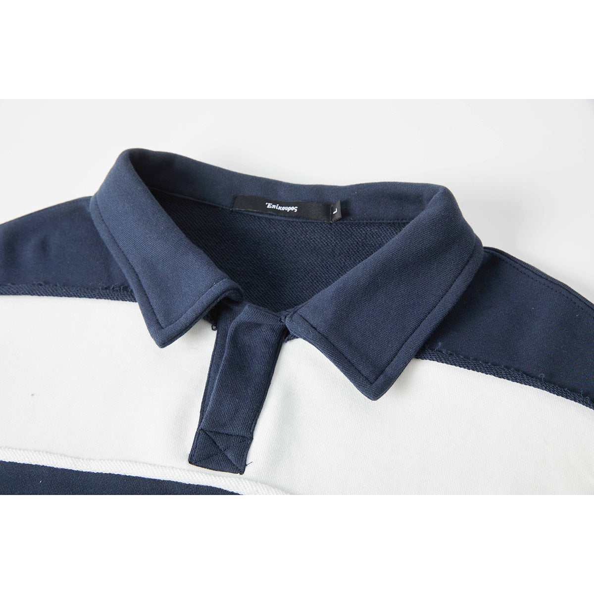 Close-up of a navy-and-white striped rugby shirt's navy collar and short button placket.
