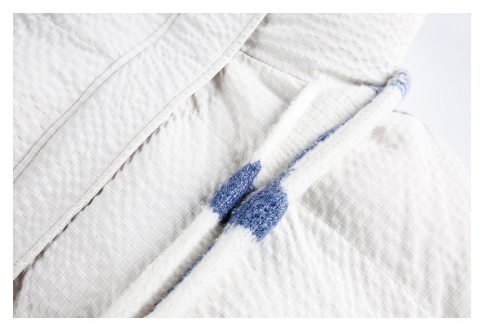 Close-up of the white quilted jacket fabric and a blue-and-white fuzzy scarf.
