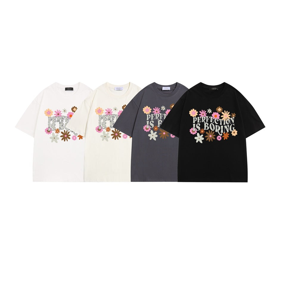 Four short-sleeve T-shirts in white, cream, charcoal, and black, each with a colorful flower graphic and “PERFECTION IS