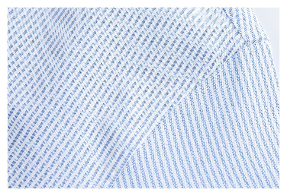 Close-up of blue-and-white striped fabric showing intersecting seams and a folded edge.