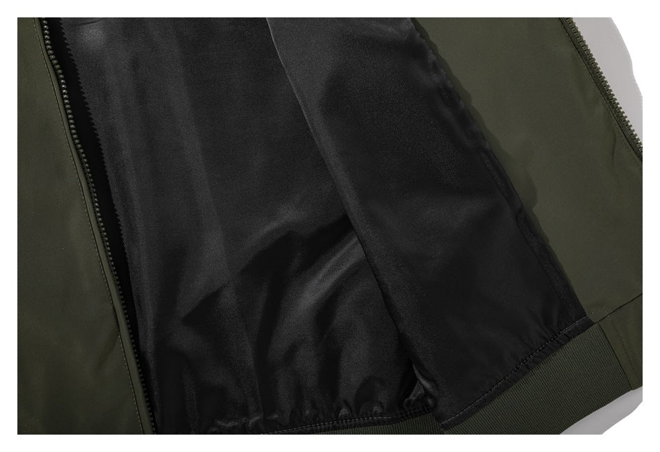 Close-up of an olive jacket opened to show its dark inner lining and zipper.