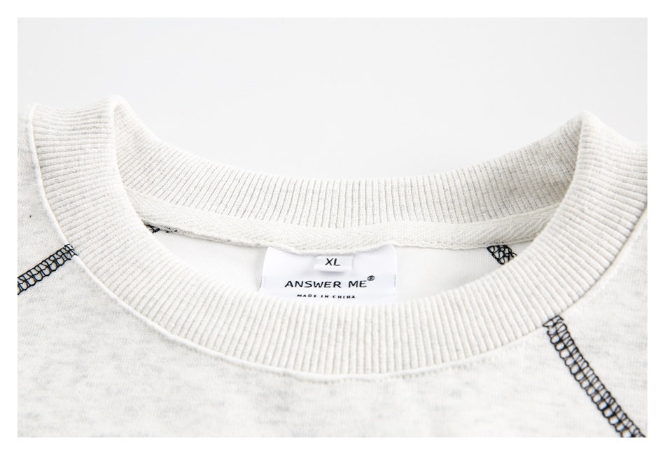 Close-up of a ribbed crew neckline, black seam stitching, and an ANSWER ME size label.