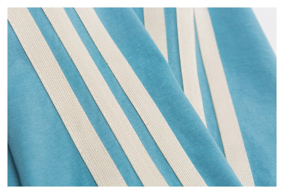 Close-up of turquoise-blue fabric with wide cream stripes and a visible textured knit surface.