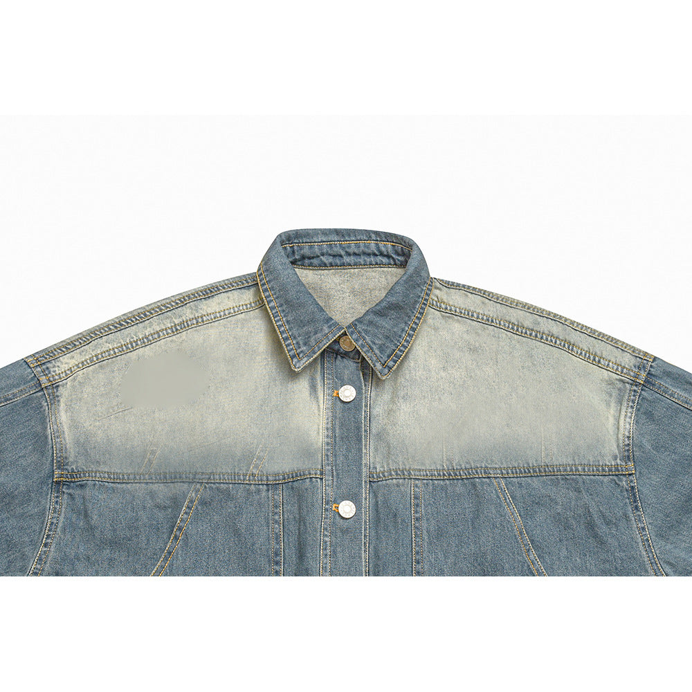 Cropped front view of a two-tone blue denim jacket with a pointed collar, button placket, and contrasting faded panels.