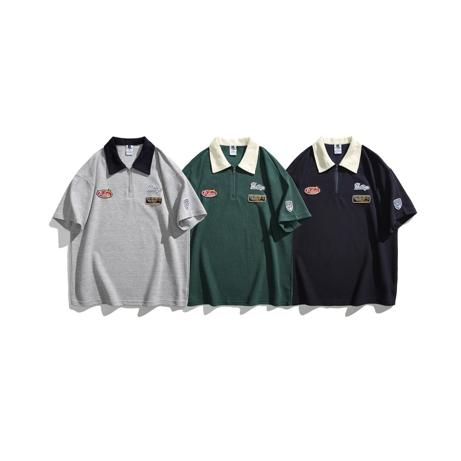 Three short-sleeve quarter-zip polos shown from the front in light gray, dark green, and navy, each with contrast collar and