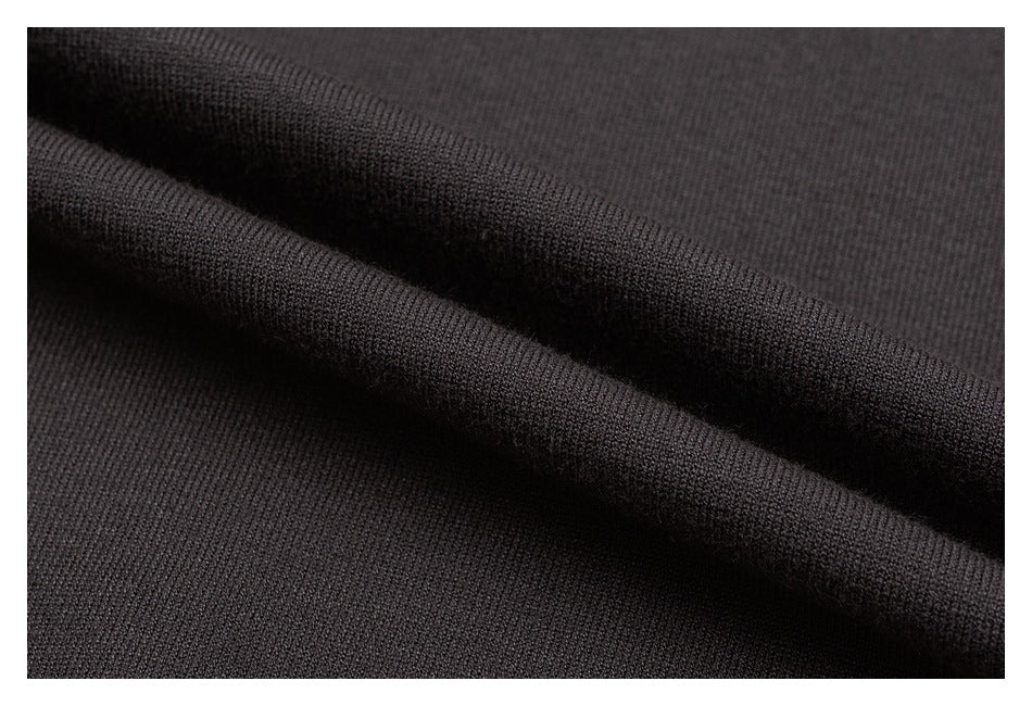 Extreme close-up of dark charcoal knit fabric folded to show its fine texture.