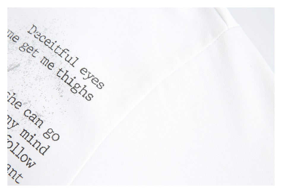 Close-up of black English text printed on white fabric near a garment seam.