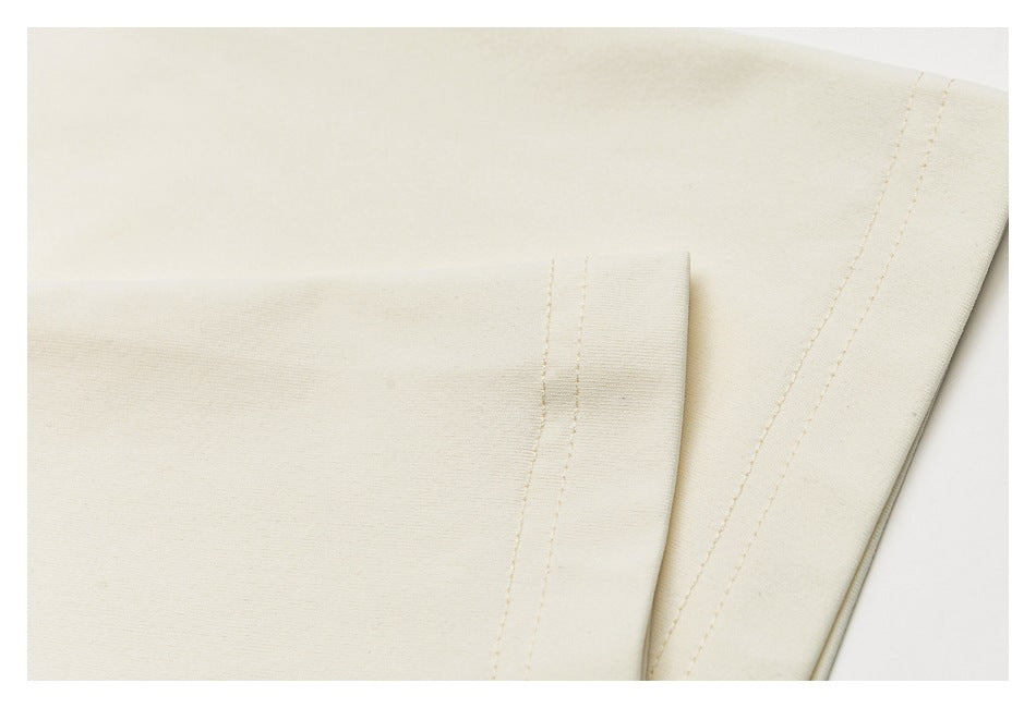 Close-up of an ivory sweatshirt sleeve and stitched hem finish.