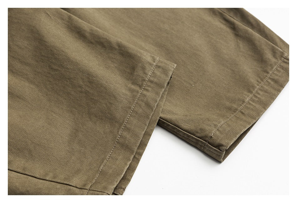 Close-up of olive-brown garment hems with visible stitching and folded fabric edges.