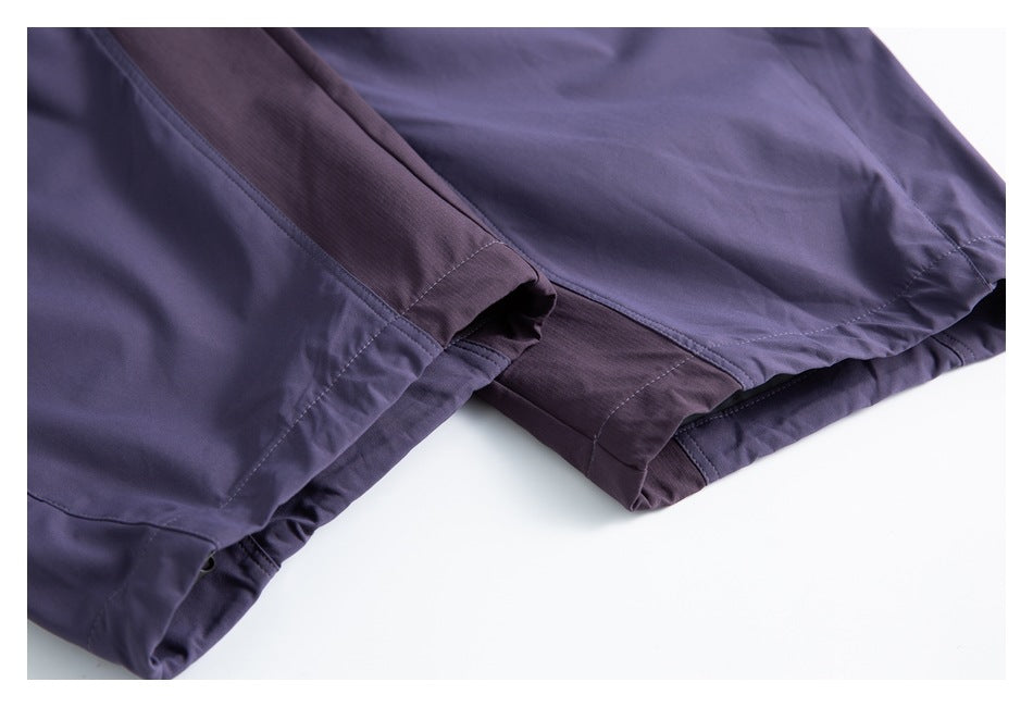 Close-up of the purple shorts' stitched leg hems and gathered edge.