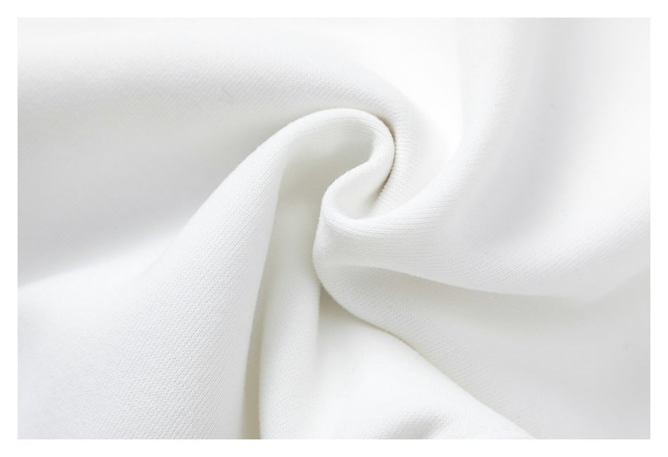 Close-up of white fabric draped into soft folds, showing its fine surface texture.