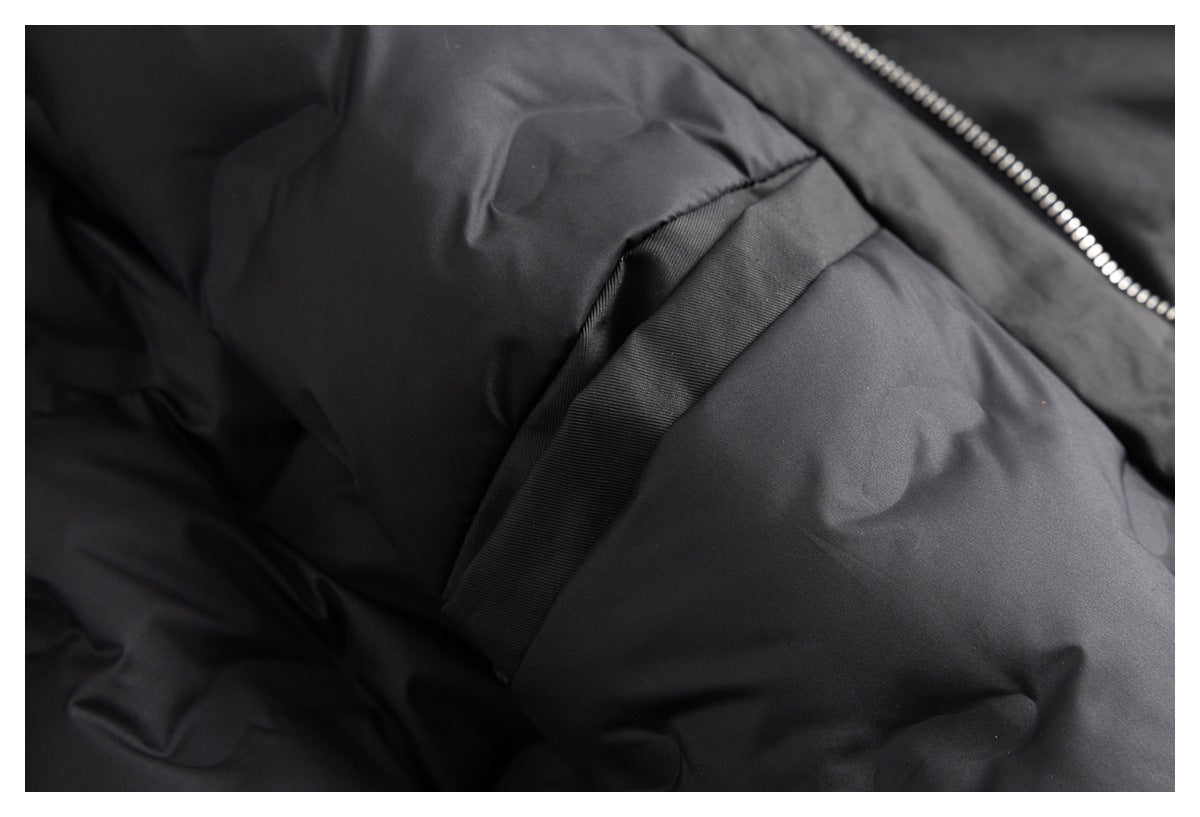 Close-up of black garment fabric and a pocket edge beside a silver zipper.
