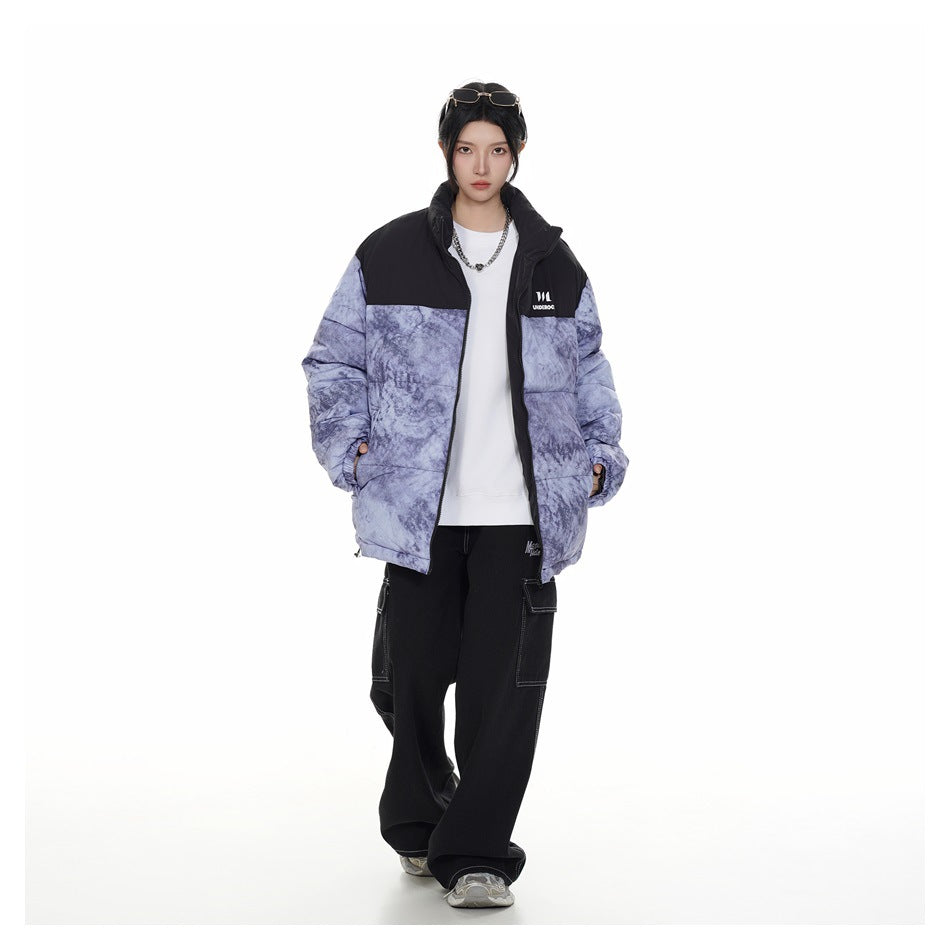 Model wearing the black and blue marbled puffer jacket open over a white top with black cargo pants