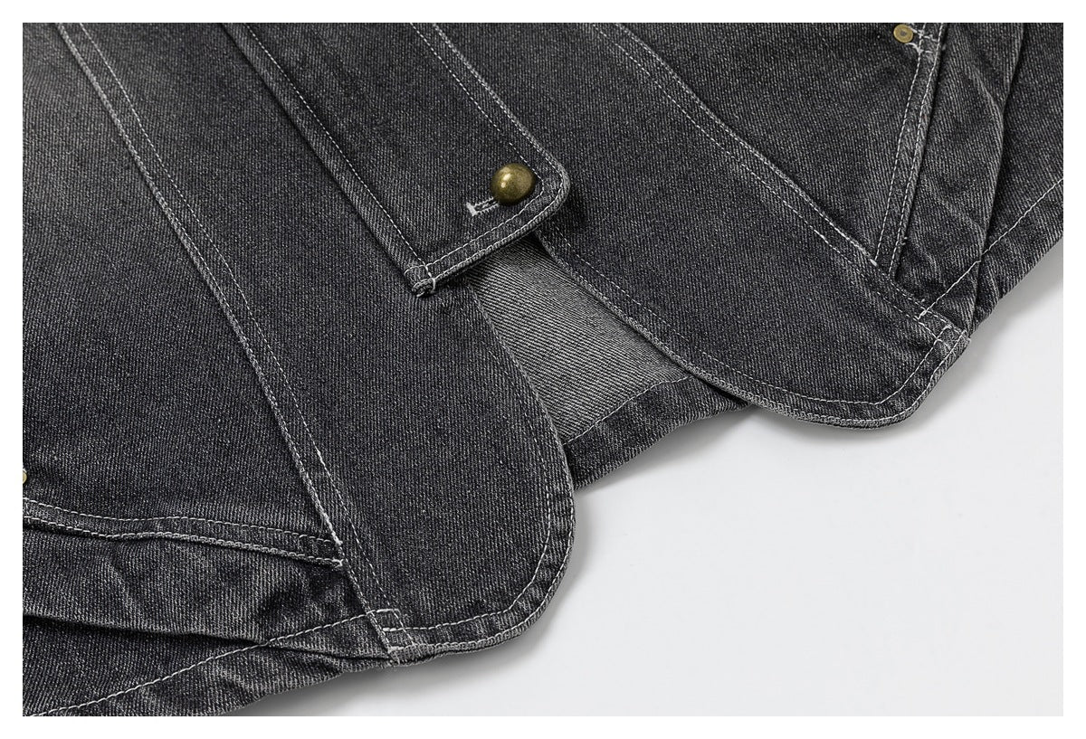 Close-up of charcoal denim panels and overlapping buttoned tabs with contrast stitching.