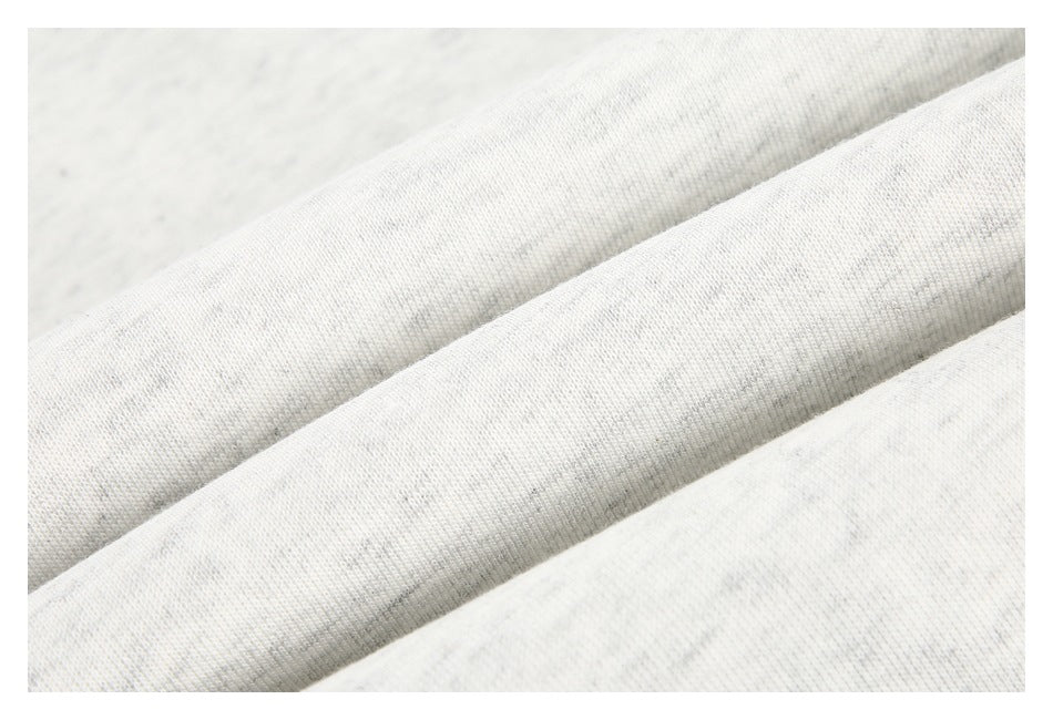 Close-up of the light gray heather garment fabric arranged in soft folds.