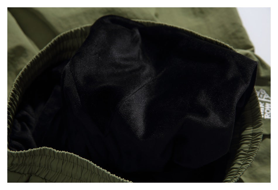 Close-up inside olive-green shorts showing a black inner fabric panel and elastic waistband.