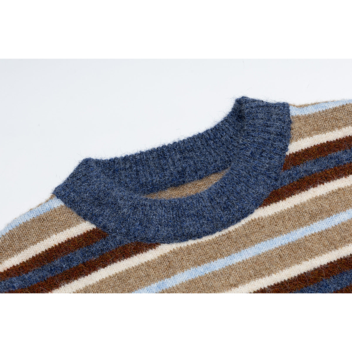 Close-up of a navy ribbed crew neckline on a tan, cream, brown, and light blue striped sweater.