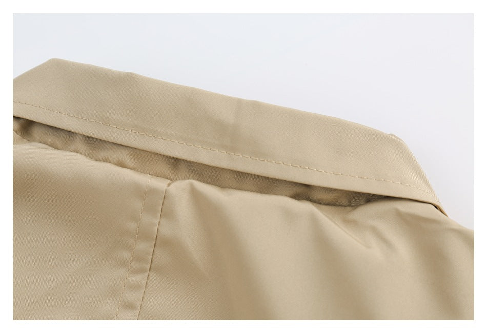 Close-up of a beige garment collar with visible topstitching and a seam below.