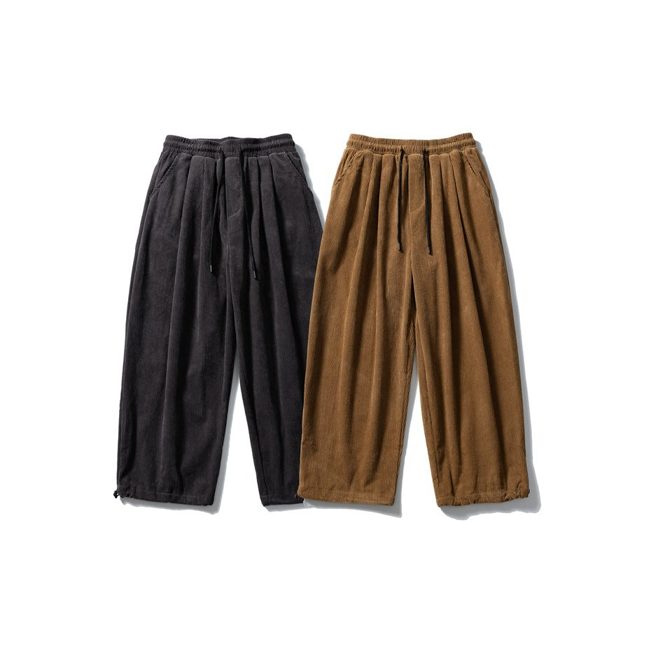 Two pairs of loose corduroy pants shown from the front in charcoal and brown, with elastic waists and drawstrings.