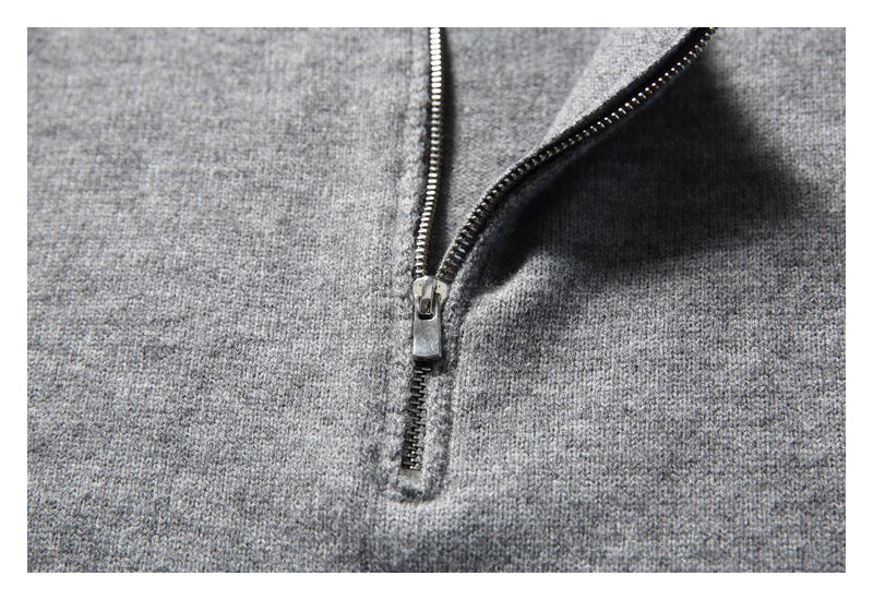 Close-up of a metal zipper on heather gray knit fabric.