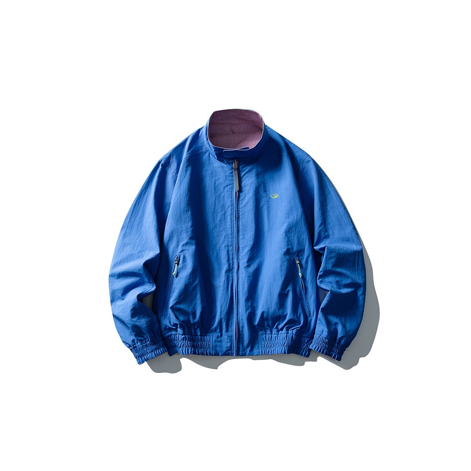 Front view of a bright blue zip-front jacket with a stand collar, two zip pockets, and elasticated cuffs and hem.