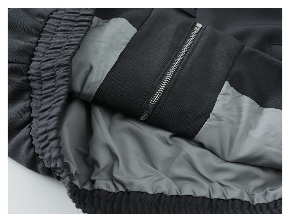 Close-up of a black garment's gray lining, elasticized edge, and silver zipper.