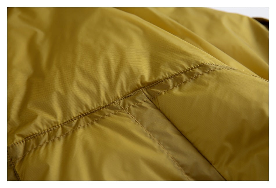 Close-up of a stitched seam and pocket panel on the mustard-yellow jacket.