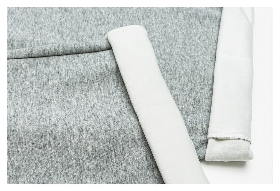 Close-up of a gray heathered garment beside white fabric edges and a finished cuff.