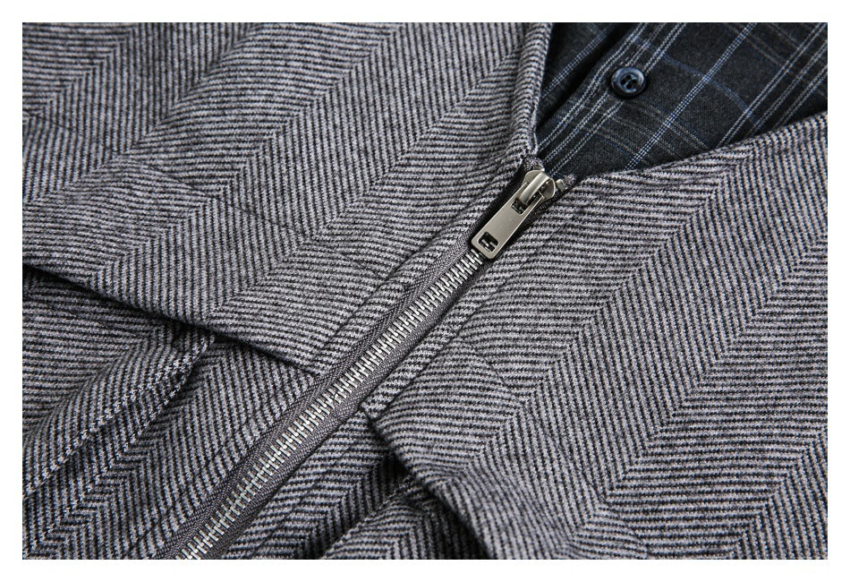 Close-up of the gray herringbone jacket's silver zipper and dark plaid lining.