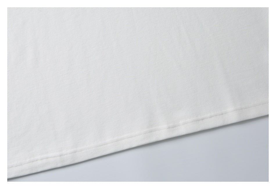 Close-up of the stitched hem on a white garment against a pale background.