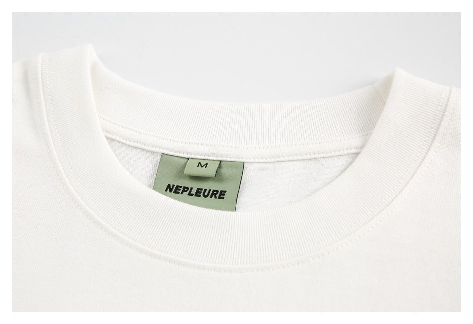 Close-up of a white T-shirt's ribbed crew neck and sewn-in size and brand labels.