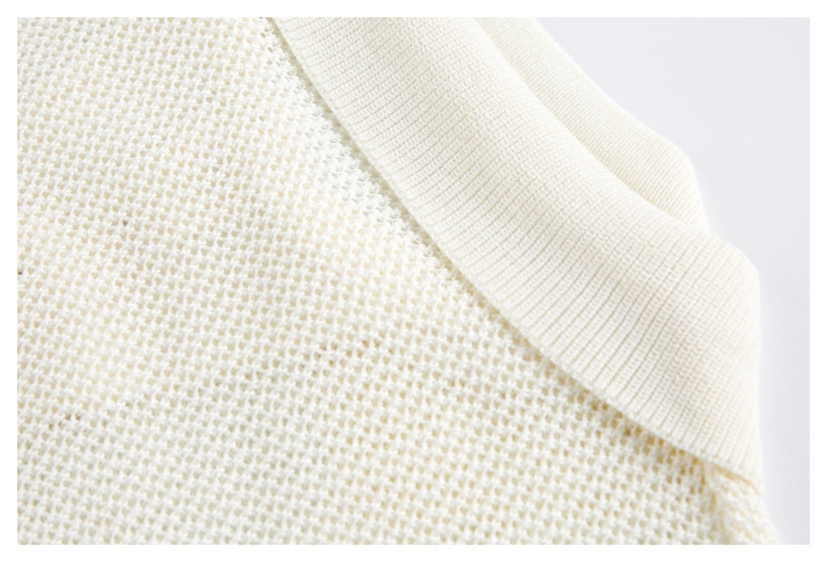 Close-up of a cream knit garment showing its textured body and wide ribbed neckline.