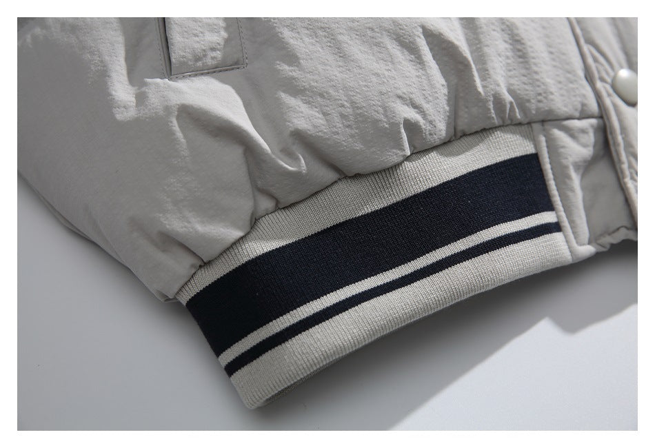 Close-up of the jacket's cream ribbed hem with dark horizontal stripes.
