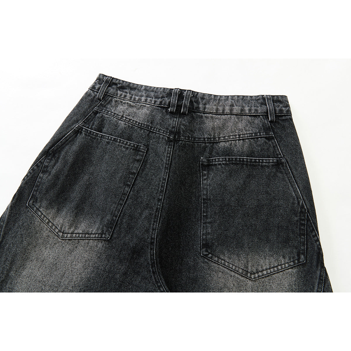 Close-up of the back waistband and two patch pockets on black washed denim trousers.