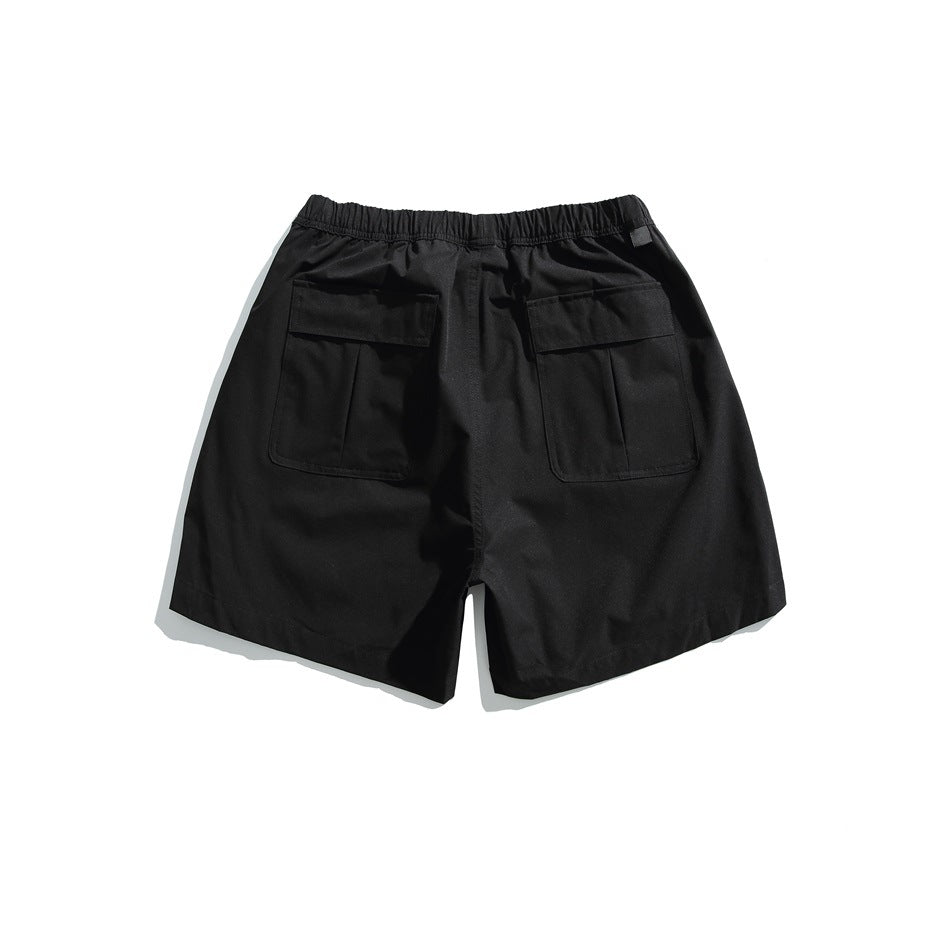 Back of black shorts with an elastic waist and two large flap pockets.
