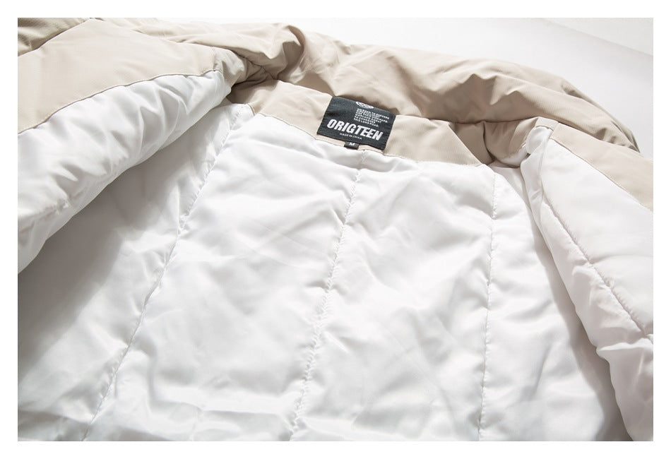 Close-up of a beige jacket's white quilted lining and sewn black ORIGITEEN neck label.