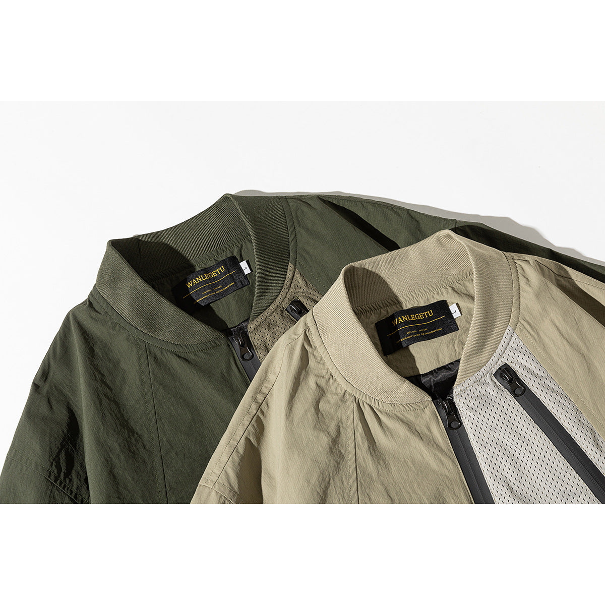 Close-up of two jacket collars and zip fronts in dark olive and khaki, with ribbed neckbands and mesh panels.
